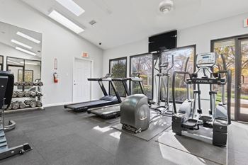 A gym with treadmills, weights, and exercise equipment. at Woodland Park Apartment Homes, Greensboro, NC, 27455